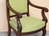 une chaise verte avec une structure en bois et une assise rembourrée verte