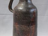 a brown vase that is sitting on a white surface