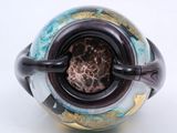 a close up of a vase on a white surface