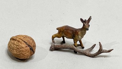 figurines of a deer and a walnut on a white surface