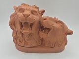 une sculpture en argile représentant deux lions la gueule ouverte
