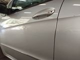 a silver car parked in a garage with its door open