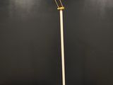 un lampadaire blanc posé sur une table noire, avec un mur noir en arrière-plan