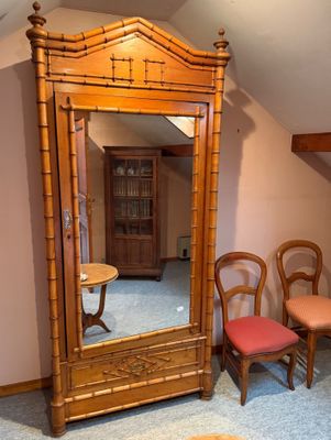 un miroir dans un coin d'une pièce où se trouvent des chaises et une table