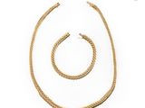 un ensemble composé d'un collier et d'un bracelet en or sur fond blanc