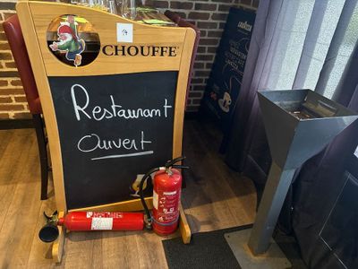 un tableau noir sur lequel est écrit « Restaurant Culvert », à côté d'un extincteur