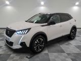 Un SUV blanc est garé dans une pièce au sol carrelé en damier.