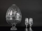 un vase en verre et deux verres à vin posés sur une table
