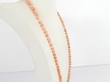 a close up of a necklace on a mannequin with orange beads