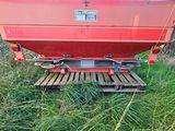 a red boat sitting on a wooden platform in the grass