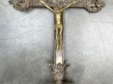 une croix posée sur un socle, sur laquelle est fixé un crucifix