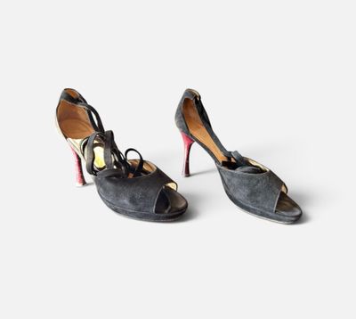 une paire de chaussures à talons hauts noires et rouges posées sur une surface blanche