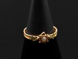 un gros plan d'une bague en or posée sur un cône noir