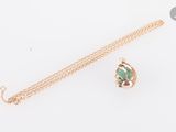 un gros plan d'un collier en or orné d'une pierre verte