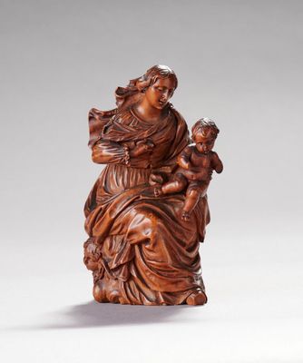 une figurine sculptée représentant une femme tenant un enfant dans ses bras