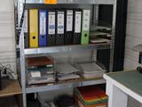 un bureau avec plusieurs dossiers et une chaise dans la pièce