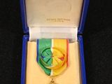 une médaille dans une boîte bleue posée sur une surface noire