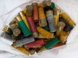 un sac blanc rempli de cartouches de fusil de chasse posé sur une table