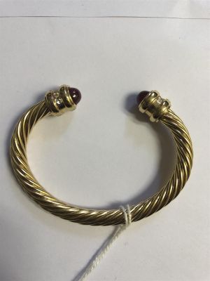 une image représentant un bracelet en or orné de grenats sur un fond blanc