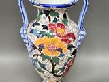 un vase avec un motif floral posé sur une table