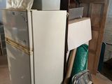 a white refrigerator sitting in the middle of a room