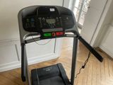 a tread machine that is on the floor in the room
