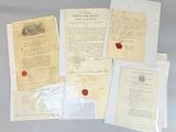 some old papers are sitting on a table with a wax seal