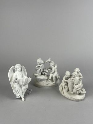 three white figurines of angels and angels on a table