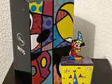 une figurine de Mickey Mouse dans une boîte, à côté d'une boîte contenant des figurines de Mickey Mouse