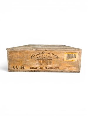 une vieille boîte en bois avec une étiquette posée sur une surface blanche