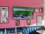 a pink wall with pictures on it and a black and white checkered floor