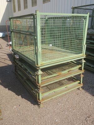 une cage verte posée au sommet d'une pile de palettes