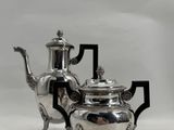 a silver tea pot and a silver teapot on a stand