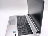 a silver laptop with a black keyboard on a white surface