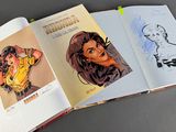 two pages of a comic book are open on a table