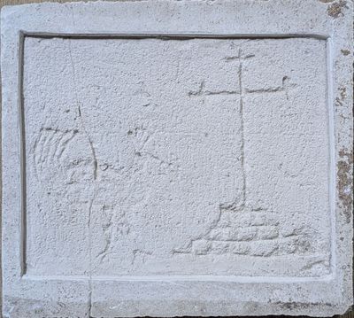 a close up of a stone plaque with a cross on it