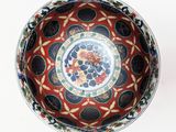 a red bowl with blue and yellow designs on it