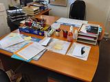 a desk with a lot of papers on it and a chair