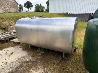 un grand réservoir métallique posé au milieu d'un champ