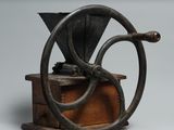 un vieux moulin à café posé sur une caisse en bois