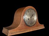 a wooden clock that is sitting on a black background