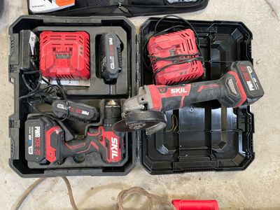 une boîte à outils posée par terre à côté d'une perceuse sans fil