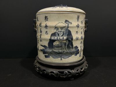 un vase bleu et blanc sur lequel est assis un homme