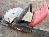 a chainsaw that is sitting on the ground next to a pole