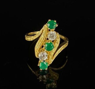 a gold ring with emerald and white diamonds