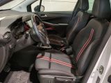 the interior of a small car with black seats and red trims