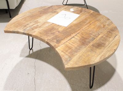 une table en bois avec des pieds en épingle à cheveux, sur laquelle est posée une pancarte