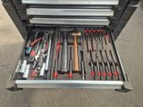 de nombreux outils dans une boîte à outils posée par terre