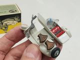 a hand holding a small toy car in front of a box