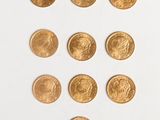 several gold coins are arranged in a triangle on a white surface